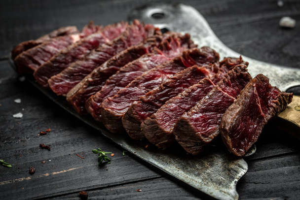 Et kasabı bıçağının üstünde ızgara biftek. Yemek tarifi geçmişi. Kapat.. - Fotoğraf, Görsel