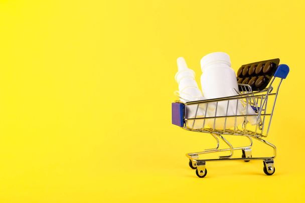 Empty mini shopping trolley, Shopping cart, Shopping basket with medicines on a yellow background. RFI Request for information. copy space - Φωτογραφία, εικόνα
