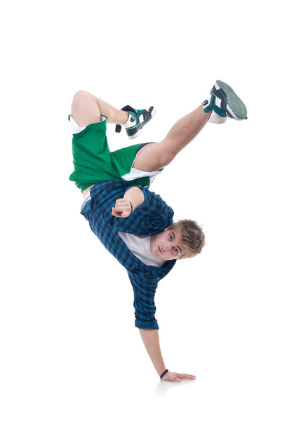 Young bboy standing on one hand. Holding legs in air. Looking and pointing at camera. Isolated on white in studio. Front view, whole body - Foto, imagen