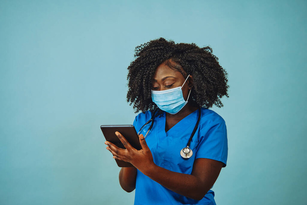 Nurse practitioner doctor with face mask, tablet and stethoscope - Photo, Image