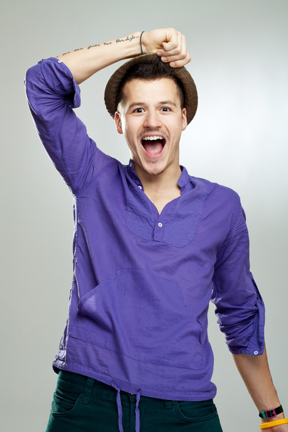 Portrait of excited young man wearing a hat celebrating success on white background - Photo, Image