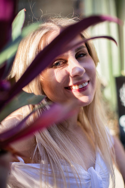 Romantic blond hair european white model with a plant - Foto, afbeelding