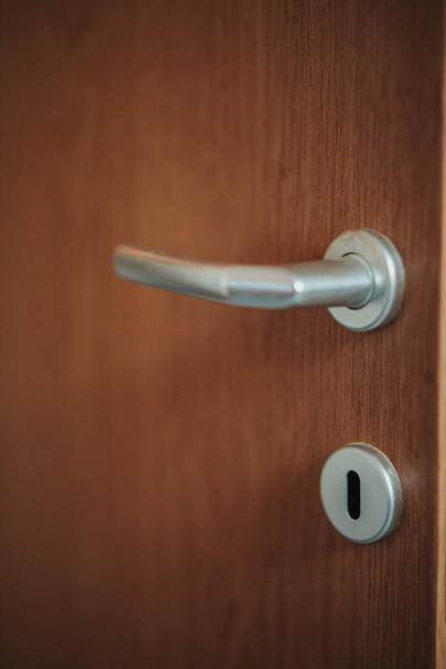 A vertical shot of a wooden door lock on a blurred background - Fotó, kép