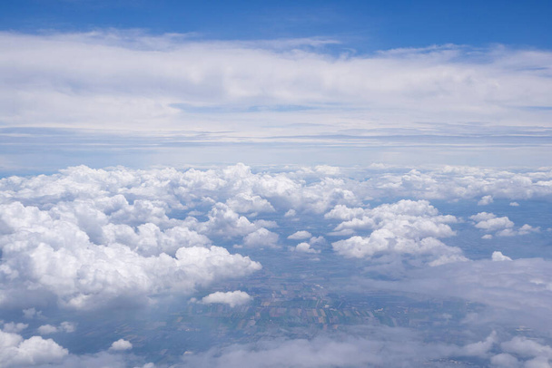 Вид з повітря на хмари і небо, видимий через вікно літака
. - Фото, зображення