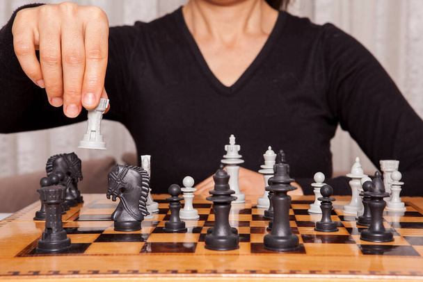 Kobieta grająca w szachy wykonuje swój ruch. Koncepcja strategii biznesowej i taktyka. - Zdjęcie, obraz