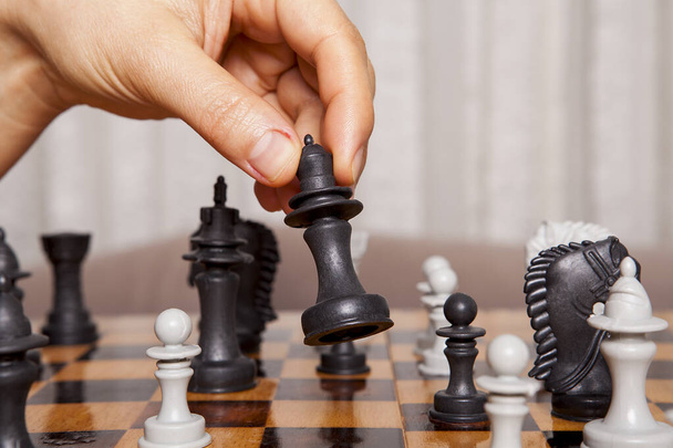 Femme jouant au jeu d'échecs fait son mouvement. Concept de stratégie et de tactique d'entreprise. - Photo, image