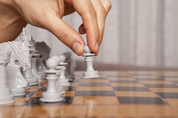 De vrouw die schaakspel speelt maakt zijn zet. Concept van bedrijfsstrategie en tactiek. - Foto, afbeelding