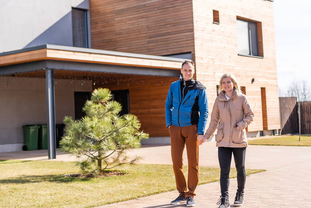 Happy family standing near their new house - Fotoğraf, Görsel