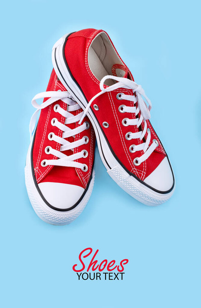 Red sneakers on blue background with copy space. Youth shoes. - Foto, Imagen
