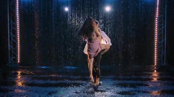 Love story of couple in the rain, expressed in a passionate dance. Romantic meeting of two lovers. The wet bodies of man and a woman, covered in glistening drops in the soft studio light. Slow motion. - Metraje, vídeo