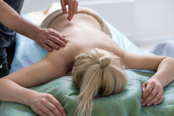 Massage and body care. Therapeutic spa body massage. Woman lying and relaxing at massage in a cosy home environment. Female having massage - Φωτογραφία, εικόνα