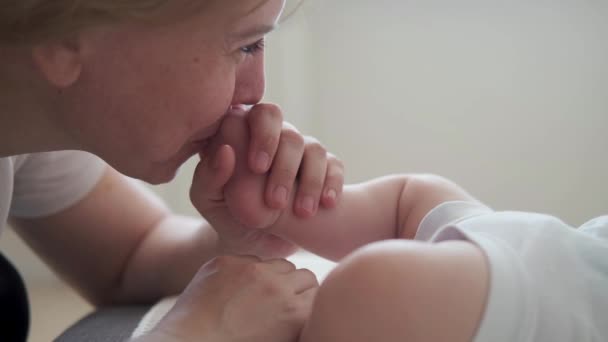 4k. Atraente mãe feliz beijo farejar pequenos meninos dedos do pé. Família feliz - Filmagem, Vídeo