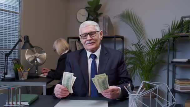 Iloinen vanhempi yritysjohtaja juhlii liiketoiminnan menestystä tanssia rahan dollarilla käteistä - Materiaali, video