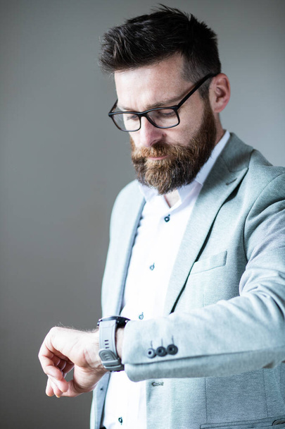 zakenman op zoek naar hand horloge  - Foto, afbeelding