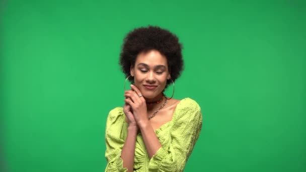 Усміхнена афро-американська жінка дивиться на фотоапарат, ізольований зеленим кольором.  - Кадри, відео