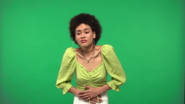 Mujer afroamericana que sufre de dolor de estómago aislado en verde - Imágenes, Vídeo