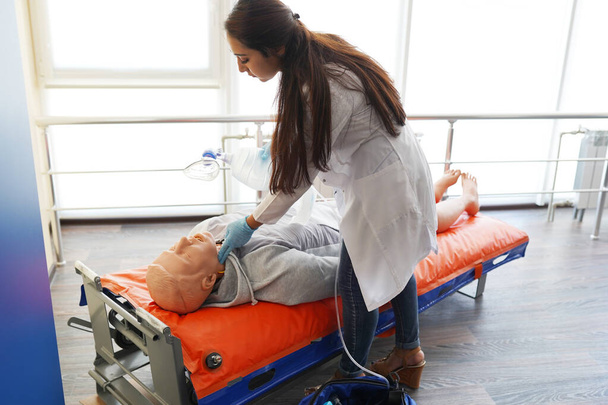 Μαθητής νοσηλευτικής μαθαίνει πώς να σώζει τους ασθενείς σε περίπτωση έκτακτης ανάγκης. CPR εκπαίδευση με κούκλα CPR. - Φωτογραφία, εικόνα
