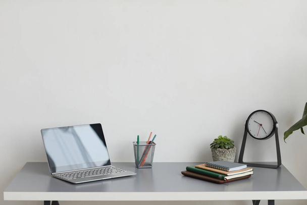 Минимальное фоновое изображение рабочего места домашнего офиса с ноутбуком на столе, копировальное пространство - Фото, изображение