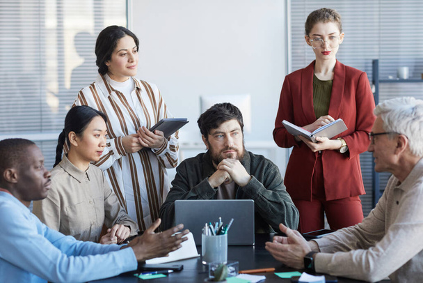 Vista frontal em diversos grupos de empresários que planejam o projeto juntos enquanto se sentam à mesa durante a reunião no escritório - Foto, Imagem