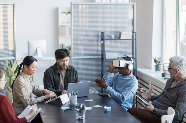 Πορτρέτο της διαφορετικής ομάδας πληροφορικής ανάπτυξη λογισμικού για το έργο εικονικής πραγματικότητας, εστίαση στην Αφρο-Αμερικανός άνθρωπος χρησιμοποιώντας VR στο γραφείο - Φωτογραφία, εικόνα