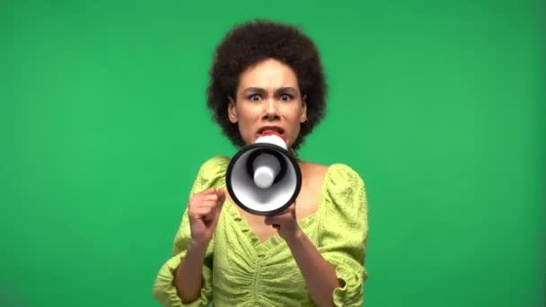 Mujer afroamericana gritando en megáfono aislado en verde  - Metraje, vídeo