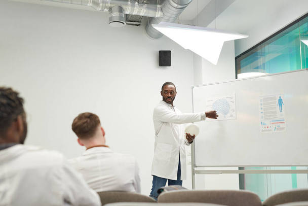 Laaja kulma näkymä Afrikkalainen-amerikkalainen mies seisoo valkotaulu antaessaan seminaari lääketieteen college, kopioi tilaa - Valokuva, kuva