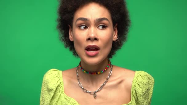 Podekscytowana Afroamerykanka w masce medycznej odizolowana na zielono  - Materiał filmowy, wideo