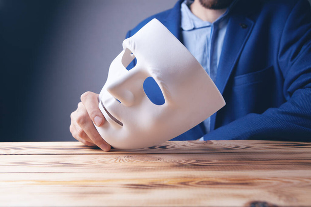 Businessman holding white mask in his hand - Photo, image