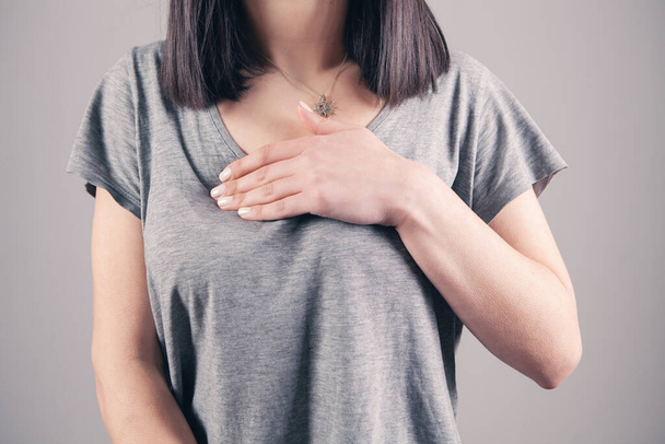 girl presses her hands on her chest chest pain - Фото, зображення