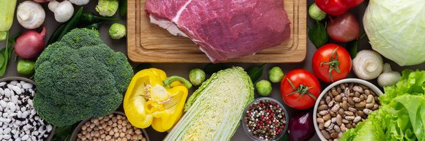 Φρέσκα λάβαρα βιολογικής καλλιέργειας λαχανικών, έννοια υγιεινής διατροφής, λαχανικά και μανιτάρια, superfoods και φασόλια γύρω από το τραπέζι με ένα μεγάλο φρέσκο κομμάτι φιλέτο βοδινού, top view - Φωτογραφία, εικόνα