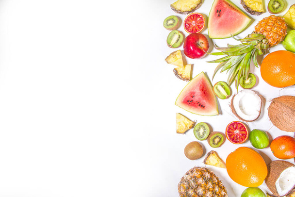 Zomer vitamine food concept, diverse fruit en bessen achtergrond - watermeloen ananas appels kiwi kokosnoot oranje limoen creatieve plat lag op witte achtergrond bovenaanzicht kopieerruimte  - Foto, afbeelding