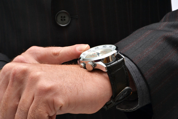 Hombre de negocios apuntando a un reloj
 - Foto, imagen