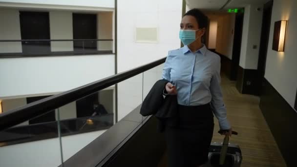 Erwachsene Frau trägt Gesichtsmaske im Hotelflur - Filmmaterial, Video