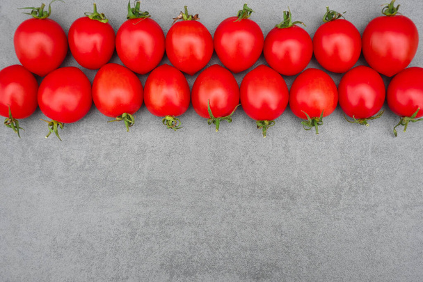 Red fresh ripe tomatoes lie on a gray background.Food concept. Healthy food, ripe vegetables - Photo, Image