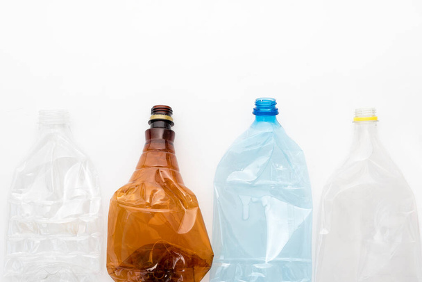 Různé typy drcených plastových lahví na bílém pozadí. Kopírovací prostor pro text. Recyklovatelný odpad. Recyklace, opětovné použití, likvidace odpadu, zdroje, životní prostředí a koncepce ekologie - Fotografie, Obrázek