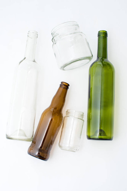 Beyaz arka planda farklı tipte cam şişeler. Geri dönüşümlü atık. Geri dönüşüm, yeniden kullanım, çöp öğütücü, kaynaklar, çevre ve ekoloji kavramı - Fotoğraf, Görsel
