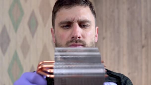 The man blows the dust off the heatsink of the pcs central processor with his mouth. Home pc maintenance and upgrade - Кадры, видео