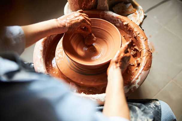Female potter hands making clay pot in pottery studio - Photo, Image