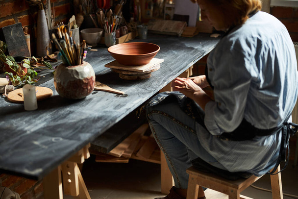 Female ceramic artist working in pottery workshop - Φωτογραφία, εικόνα