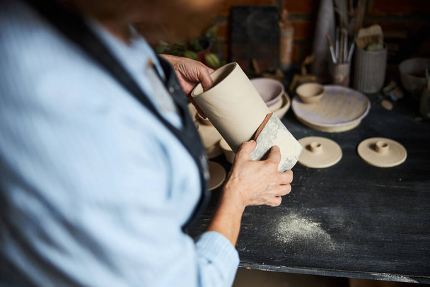 Le mani di vasaio femminili lucidano la ceramica in officina - Foto, immagini