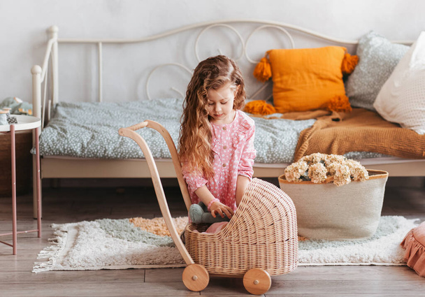 Bambina gioca con i giocattoli sul pavimento nella camera da letto dei bambini - Foto, immagini