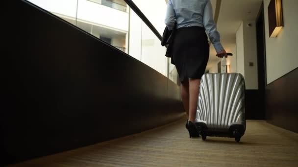 Mujer con maleta caminando por el pasillo del hotel - Metraje, vídeo