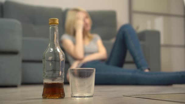 Μια νεαρή γυναίκα κοιμάται μετά το ποτό στο πάτωμα. Γυναικείος αλκοολισμός - Πλάνα, βίντεο