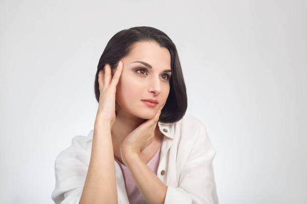 Портрет красивої брюнетки-жіночої моделі з руками біля обличчя на білому тлі
 - Фото, зображення