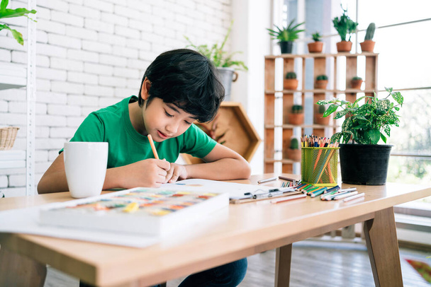 Рисунок ребенка цветными карандашами на белой бумаге с улыбкой на деревянном столе. Детское творчество выражается через искусство в детском саду и начальной школе. назад в школу. - Фото, изображение