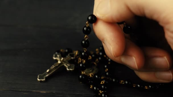 Katholieke rozenkrans in de handen van een persoon bidden - Video
