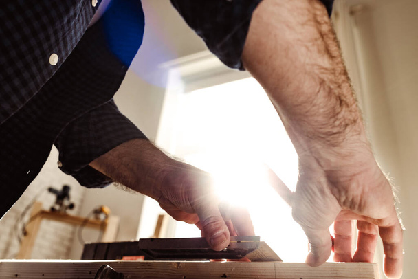 Male carpenter working with a wooden bar in a workshop - Φωτογραφία, εικόνα