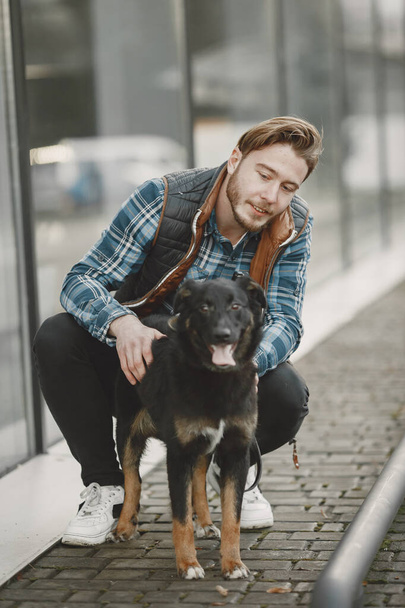 Man with a dog in a city - Фото, зображення