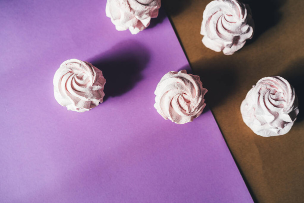 Čerstvé marshmallows na fialovém pozadí. Zephyr, pusinka. Koncept domácího jídla, sladkostí. Minimalismus, pohled shora, plochá poloha, kopírovací prostor. - Fotografie, Obrázek