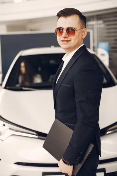 Hombre guapo y elegante en un salón de coches - Foto, Imagen